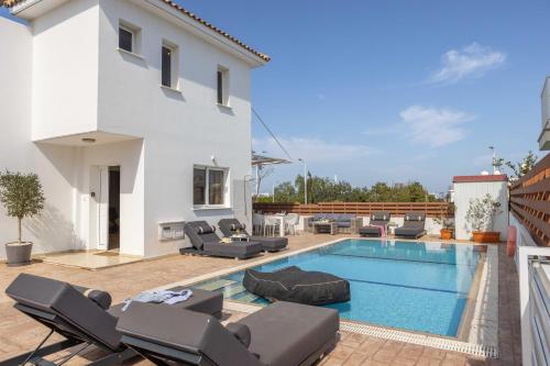 a villa with a swimming pool and patio furniture at Villa Protaras View 9 Central Protaras -Fig Tree Bay-Jacuzzi-Hot Tub in Protaras