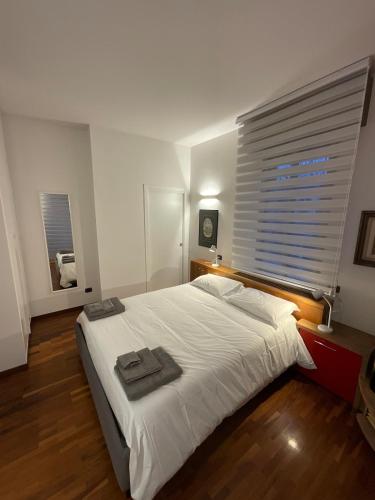 a bedroom with a large white bed and a window at La casa dei miei in Bologna
