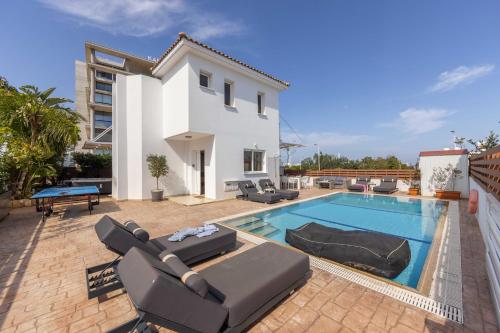 a villa with a swimming pool in front of a house at Villa Protaras View 9 Central Protaras -Fig Tree Bay-Jacuzzi-Hot Tub in Protaras