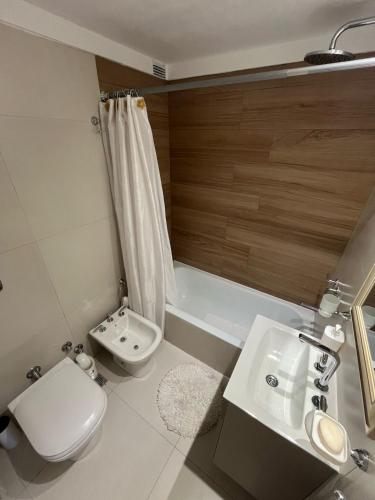 a bathroom with a toilet and a sink and a tub at Gorriti Apartment in Lomas de Zamora