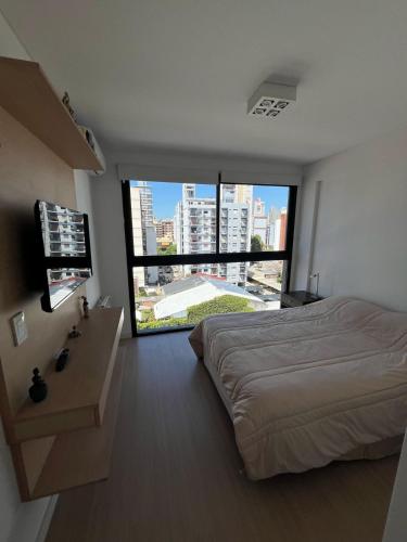 a bedroom with a bed and a large window at Gorriti Apartment in Lomas de Zamora