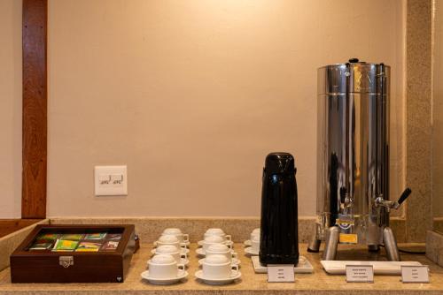 a counter top with a coffee maker and cups at Hotel Villa Reggia in Rio de Janeiro