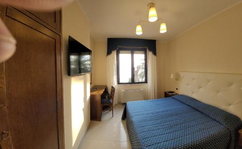 a bedroom with a blue bed and a window at Hotel Eden Sul Lago in Bolsena