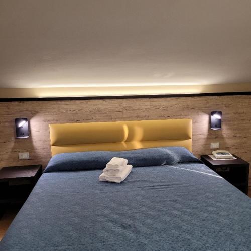 a bedroom with a blue bed with a yellow headboard at Hotel Eden Sul Lago in Bolsena