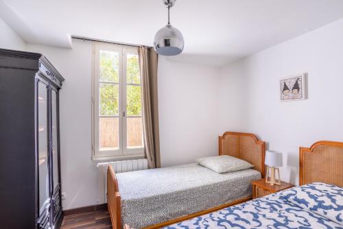 une chambre avec deux lits et une fenêtre dans l'établissement Appartement 6 personnes en centre-ville et piscine, à Hyères