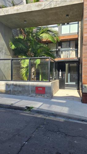 a building with a palm tree in front of it at Departamento centro in Paraná