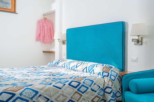 a bedroom with a bed and a blue chair at L'antica Pigna Chateau in Vico Equense
