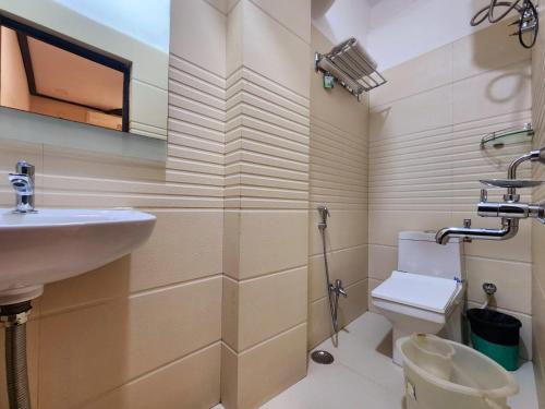 a bathroom with a sink and a toilet at Hotel Raunak in Kolkata