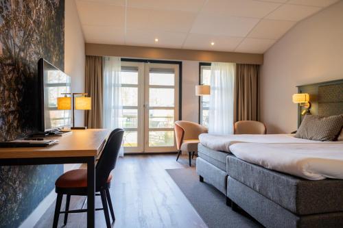 a hotel room with a desk and a bed and a desk sidx sidx sidx sidx at Parkhotel Tjaarda in Oranjewoud