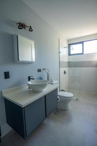 a bathroom with a sink and a toilet at La Parada House in Heredia