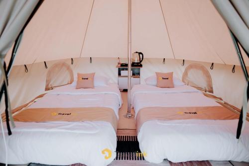 a group of three beds in a tent at Glamping Telaga Menjer By Travelink in Kejajar