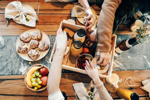 a group of people holding their hands over a table with food at Naturhof eibl in Grossarl