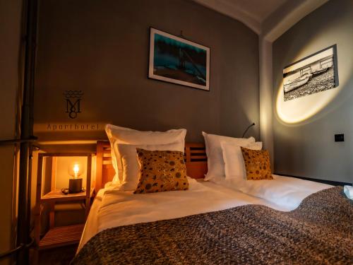 a bedroom with a bed with white sheets and pillows at MARIENSZTAT 8 Aparthotel in Warsaw