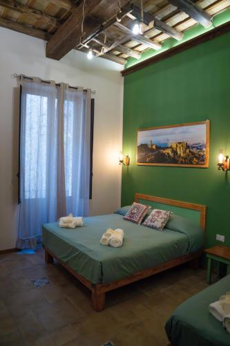 a bedroom with a bed with a green wall at Antichi Sapori Appartamenti in Trapani