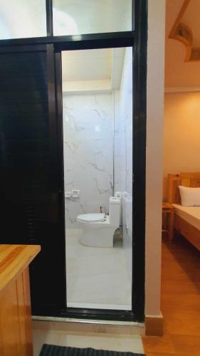a bathroom with a tub and a toilet through a window at Tuking Mt Inn and Restaurant in Sagada