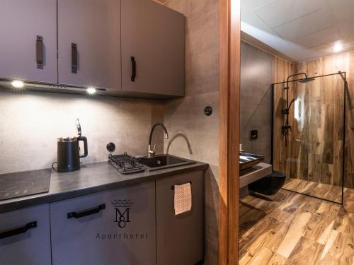 a small kitchen with a sink and a shower at MARIENSZTAT 8 Aparthotel in Warsaw