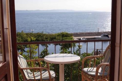 a balcony with a table and chairs and the ocean at Apartments Tonci in Podgora