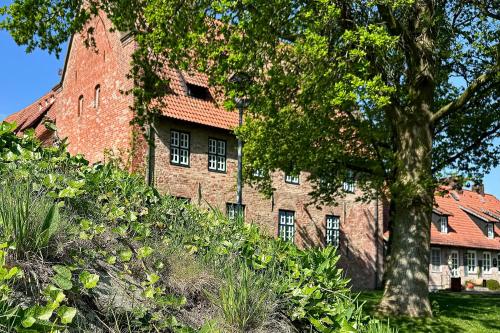 an old brick building with a tree in front of it at Hausboot "Seestern" in Bad Bederkesa