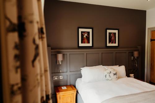 a bedroom with a bed and two framed pictures on the wall at The Fleece at Ruleholme in Carlisle