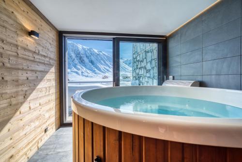 a tub in a bathroom with a mountain view at Chalet Arktic - Catered Chalet - Sleeps 14 in Tignes