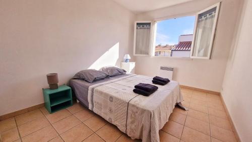une chambre avec un lit et une fenêtre dans l'établissement Villa LA DIVA Agréable villa familiale climatisée proche plage - 3 chambres - jardin et terrasse, à Saint Cyprien Plage