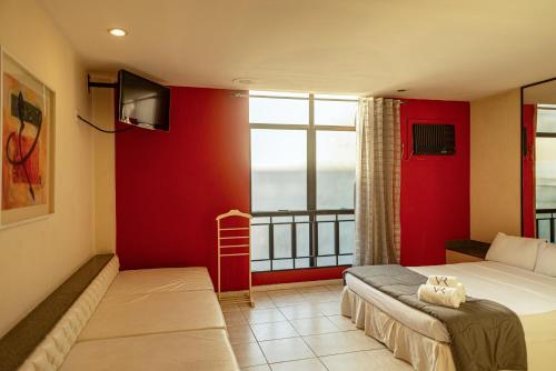 a bedroom with a bed and a red wall at Hotel Villa Reggia in Rio de Janeiro