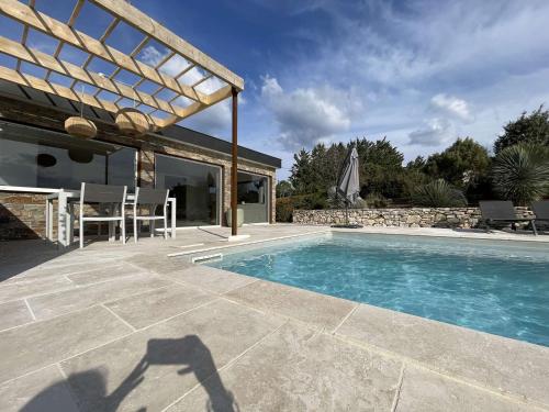 - une piscine avec une table et des chaises à côté d'une maison dans l'établissement Maison à Saint-Remèze avec Piscine, 8 Pers, Animaux Acceptés, Jardin 2000m² et Studio Indépendant - FR-1-382-201, à Saint-Remèze