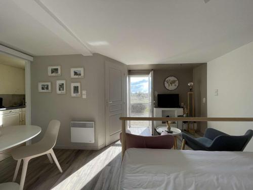 un salon avec une table et des chaises et une cuisine dans l'établissement Maison à Saint-Remèze avec Piscine, 8 Pers, Animaux Acceptés, Jardin 2000m² et Studio Indépendant - FR-1-382-201, à Saint-Remèze