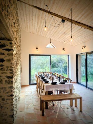 une grande salle à manger avec une longue table et des chaises dans l'établissement Le Champ des Grenouilles - gîte écologique à la ferme, à Montjoie-en-Couserans