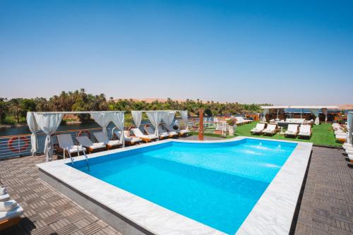 a swimming pool on the roof of a building with chairs at Acamar Nile Cruise - Every Monday from Luxor for 04 & 07 Nights - Every Friday From Aswan for 03 & 07 Nights in Luxor