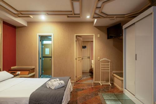 a hotel room with a bed and a television at Hotel Villa Reggia in Rio de Janeiro