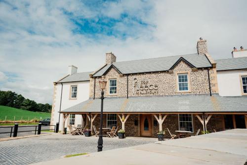 a large brick building with a black roof at The Fleece at Ruleholme in Carlisle
