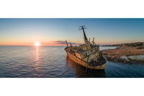 an old boat sitting in the water at sunset at Argaka Sunset Villa in Argaka