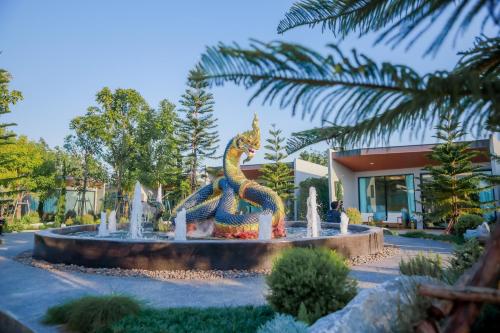 a statue of a dragon in front of a building at อนันตระปุระ รีสอร์ท บึงโขงหลง Anantara Pura Resort Bueng Khong Long in Ban Don Klang
