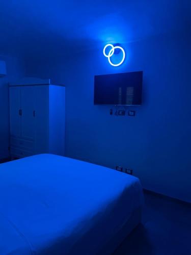 a blue bedroom with a bed and a blue light at airport apartments piano superiore in San Maurizio Canavese