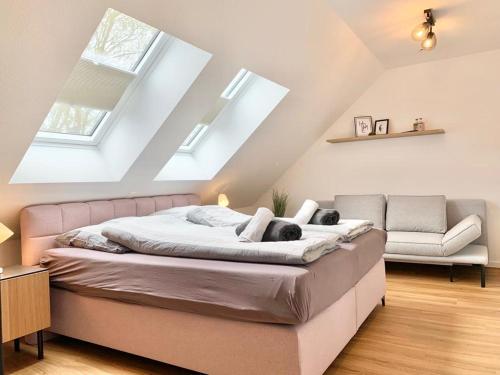 a bedroom with a large bed and a couch at Traumhaus am See und Küste für die ganze Familie in Wangerland