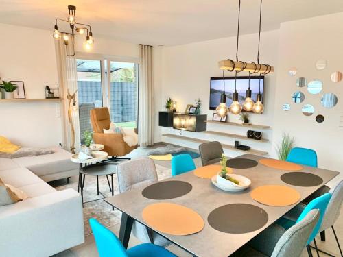 a living room with a table and chairs at Traumhaus am See und Küste für die ganze Familie in Wangerland