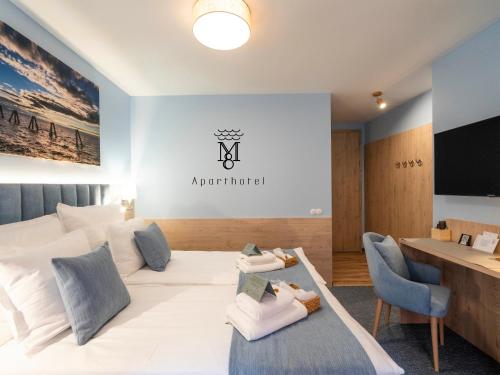 a room with a white couch and a table and a television at MARIENSZTAT 8 Aparthotel in Warsaw