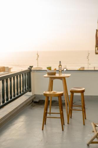 - une table et deux tabourets sur un balcon donnant sur l'océan dans l'établissement Les Basques, Vue et Acces directe à la plage, immense terrasse, place des landais Hossegor, quartier très animé, idéal pour un séjour entre amis, à Soorts-Hossegor