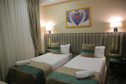 a hotel room with two beds and a picture of a heart at Essam Deluxe Hotel in Baku