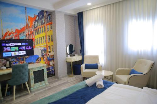 a hotel room with a bed and a desk and a tv at Essam Deluxe Hotel in Baku
