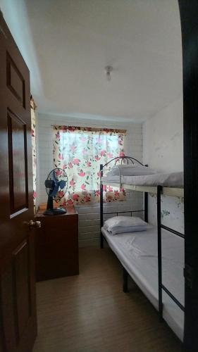a small room with a bunk bed and a window at Ka Bosun Transient House Rental in Baclayon