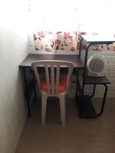 a table with a chair and a desk with a fan at Ka Bosun Transient House Rental in Baclayon