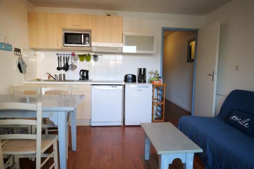 Il dispose d'une cuisine et d'un salon avec un canapé et une table. dans l'établissement Appartement pour 2-4 personnes piscine commune et parking privatif, à Les Sables-dʼOlonne