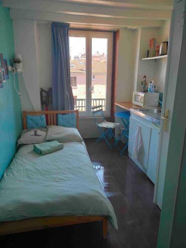 Cet appartement comprend une chambre avec un lit et une cuisine avec une fenêtre. dans l'établissement SKY BUBBLE Bright Cosy Studio in Lyon, à Lyon