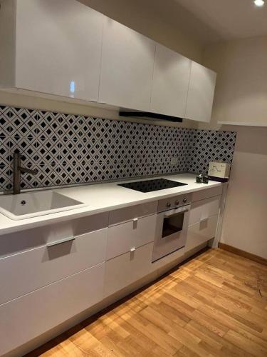 a kitchen with white cabinets and a stove top oven at Inserrata Abetone in Tuscany in Abetone