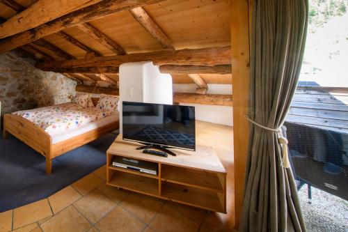 a bedroom with a bed and a television on a table at Albergo Ristorante Grotto Miralago in Miralago