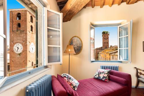 a living room with windows and a purple couch at Al Carmine Apartments Towers view with AC in Lucca