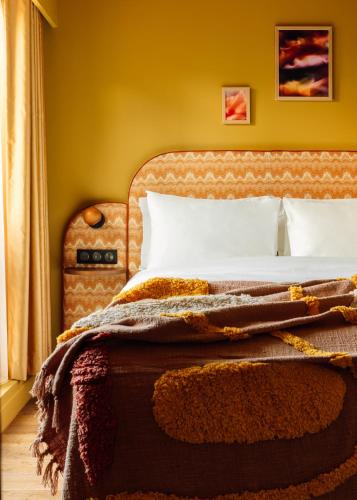 a bedroom with a bed with a blanket on it at Le Jardin de Verre by Locke in Paris