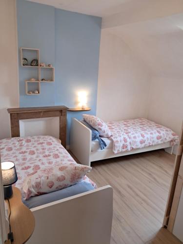 sypialnia z 2 łóżkami i stołem z lampką w obiekcie 14-18 Somme Chambres w mieście Beaucourt-sur-lʼAncre